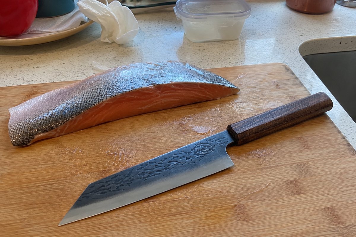Kiritsuke knife beside a fish fillet on the board