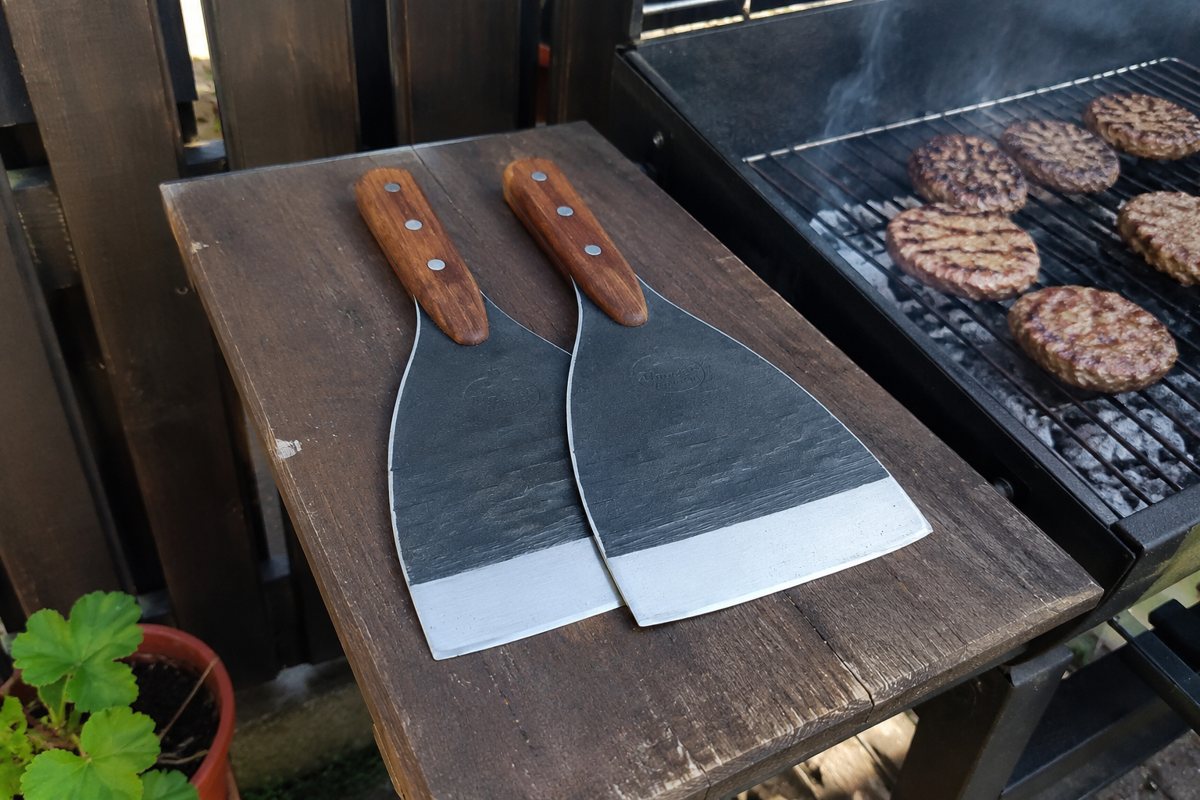 Forged spatulas by the grill with burgers