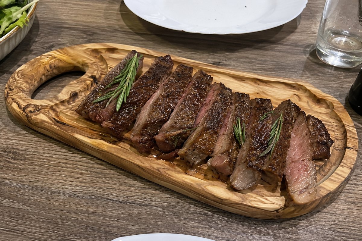 Olive-wood steak board with a sliced steak